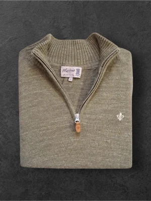 Olivgrön stickad half zip från Morris - Olivgrön stickad tröja från Morris med half zip och ribbad krage. Tröjan har lång ärm, normal passform och en liten vit broderad logga på bröstet. Materialet är mjukt och skönt, perfekt för kyliga dagar. Snygg detalj med läderdrag på dragkedjan.