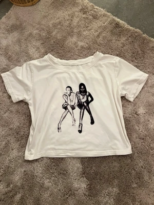Vit croppad t-shirt med print - Säljer en vit croppad t-shirt med coolt svartvitt print.