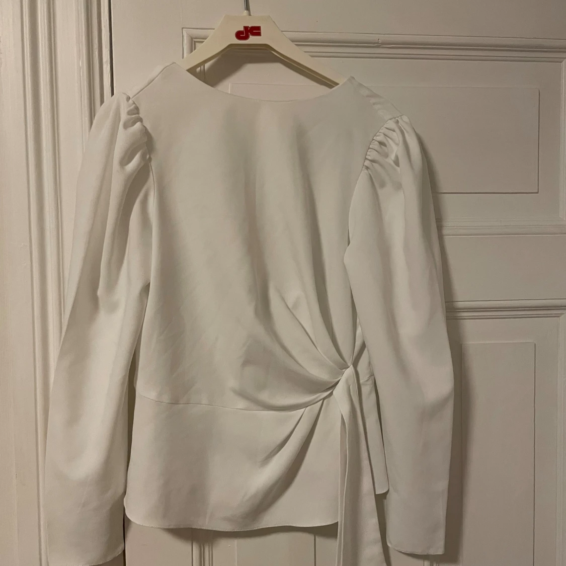 Vit blus med knytdetalj i midjan