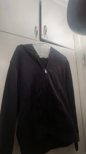 Svart polo zip hoddie. - En snygg svart polo Ralph lauren zip hoddie som kan användas till många olika klädstil. Hoddien är strl S och hade passat någon från 160-170. Använt ett par gånger men fortfarande på toppskick.
