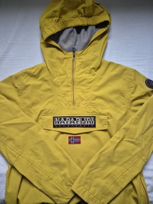 Gul vindjacka från Napapijri - Säljer en gul vindjacka från Napapijri med half zip👕 Den är i bra skick och har en väldigt bra passform, och har ni frågar skriv dm📌  [Nordic Resell]