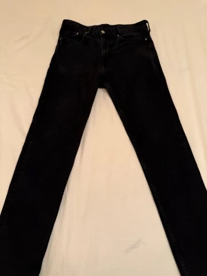 H&M Jeans Slim - Snygga svarta jeans från H&M med klassisk femficksmodell i slim fit. Jeansen har en enkel design utan slitningar och är tillverkade i ett mjukt jeansmaterial som sitter skönt. Perfekta för dig som gillar en clean och tidlös look.