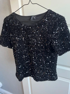 Svart paljettopp  - Jättefin svarr paljettopp från Vero Moda! Använd 2 ggr