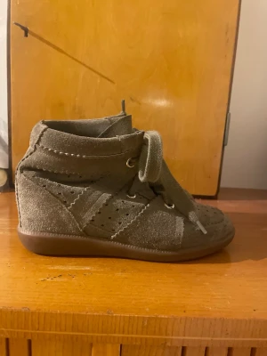 Isabel Marant skor - Säljer desssa äkta Isabel Marant skor i modellen Bobby. De är i väldigt fint skick, säljer de eftersom de är för små på mig, de är storlek 36 (äkta till storlek). De är i färgen taupé/olivfärgade eller grön/grå. De är mocka utanpå och läder inuti! 