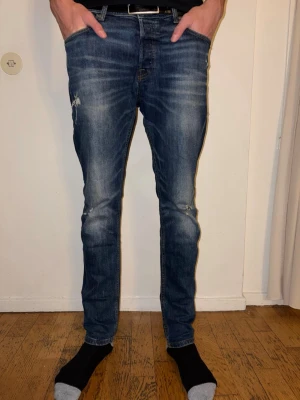 Blå slim fit jeans från Jack & Jones - Snygga blå slim fit jeans från Jack & Jones. Byxorna har använt väldigt få gånger och är där med i väldigt bra skick. Nästan nya skulle jag säga. 