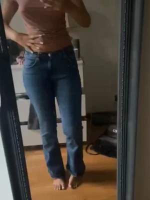 Blå bootcut jeans - mid waist - Snygga blå bootcut jeans med en medel midja. Jeansen har en fin passform som sitter tajt över höfterna och låren och släpper ut nedtill. Perfekta till en enkel topp eller hoodie för en chill look.