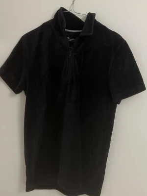 Svart kortärmad polotopp från Bondelid - Mörkblå polotopp från Bondelid i mjuk manchester med korta ärmar och half zip-dragkedja framtill. 