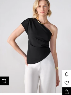 Svart oneshoulder topp - Snygg svart topp med oneshoulder-design och tight passform. Perfekt att styla med både jeans och kostymbyxor. Enkel och stilren modell som ger en trendig look. Helt ny med prislappen på