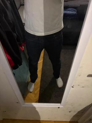 Mörkblå slim fit jeans lee - Säljer ett par mörkblå slim fit jeans med klassiska fem fickor och kontrastsömmar. Jeansen har normal midja och raka ben. Passar perfekt till en avslappnad och stilren look. Materialet är denim i bomull med lite stretch för extra komfort. lee w30 l32