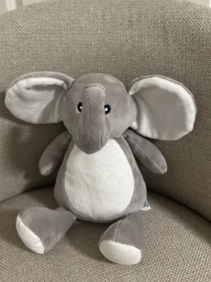 Mjukis elefant grå och vit - Supermjuk elefant i plysch med stora öron och lång snabel. Färgen är ljusgrå med vita detaljer på mage, öron och fötter. Perfekt som gosedjur eller dekoration i sovrummet. Söt design med broderade ögon.