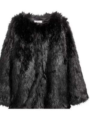 Svart pälsjacka i fuskpäls - Säljer en svart pälsjacka i mjuk fuskpäls med rund halsringning och lång ärm. Jackan sopar axlarna och har ett quiltat innerfoder för extra komfort. Perfekt för dig som vill ha en statementjacka med lyxig känsla.