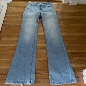 Ljusblå bootcut jeans - Säljer ett par ljusblå jeans med bootcut-modell och klassisk femficksdesign. Jeansen har en snygg tvättad look och raka ben som blir vidare nedtill. 