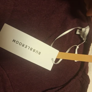 Vinröd långärmad topp från Bubbleroom - Säljer en vinröd långärmad topp från Bubbleroom med lätt struktur i tyget och v-ringad hals. Toppen har en figurnära passform och är perfekt för dig som gillar stilrena plagg med en twist. Materialet känns mjukt och följsamt.