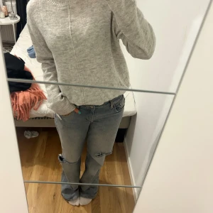 Grå stickad polotröja från KappAhl - Mysig grå stickad polotröja från KappAhl med ribbad hög krage och ribbade muddar🩷