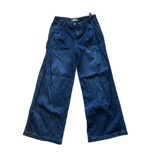 Blå wide jeans med låg/mellan midja - ZARA - Snygga blå jeans med hög midja och breda ben. Jeansen har en avslappnad passform och är tillverkade i denim för en cool och trendig look.