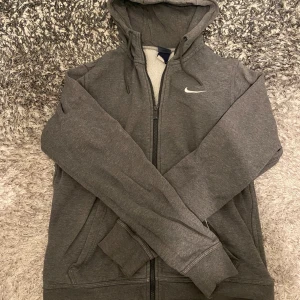 Grå nike zip hoodie - Hej😁Säljer en grå nike hoodie i storlek S som använts ibland men inga tecken. Säljer billigt. Den är äkta och fraktas samma dag eller dagen efter. Tjock material och riktigt skön. True to Size. Hör av er vid intresse💯