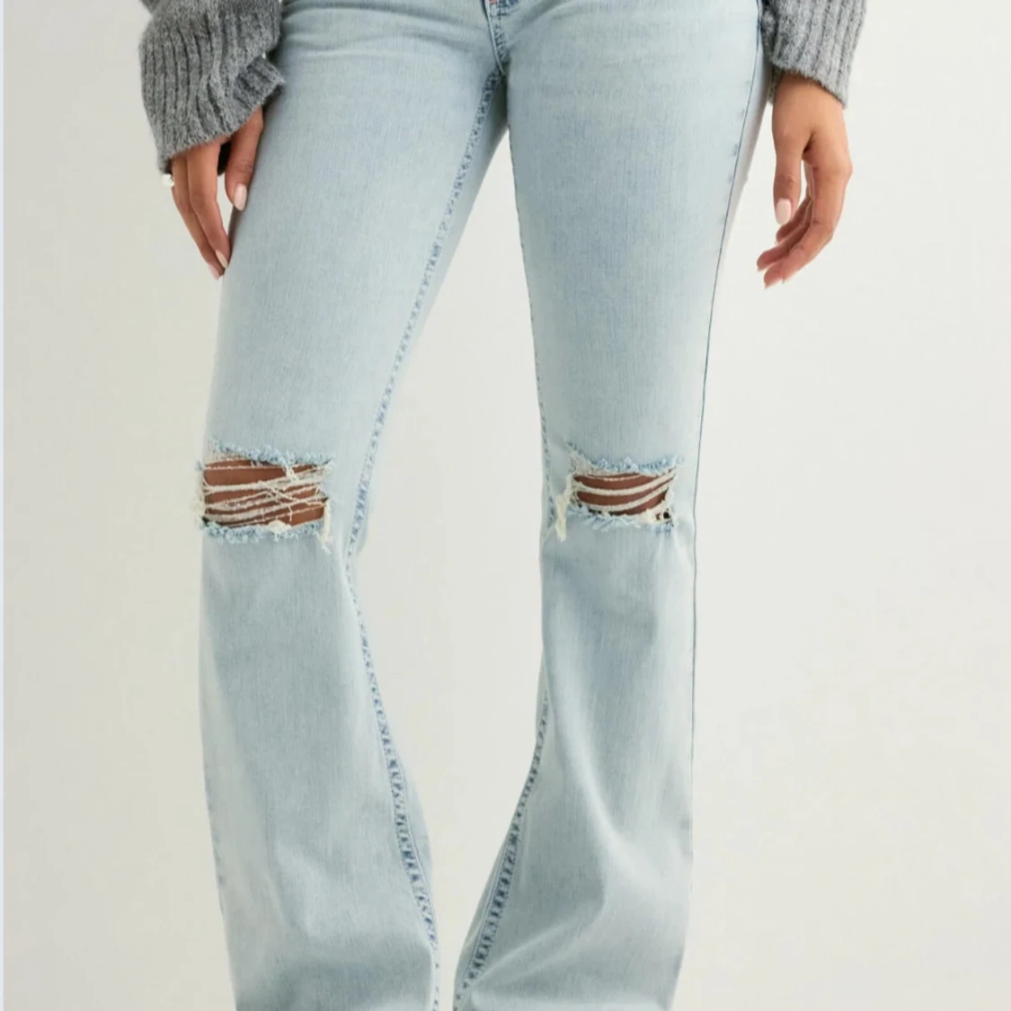 Ljusblå bootcut jeans med slitningar