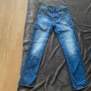 G-Star Raw 3301 Straight jeans blå - Säljer ett par klassiska G-Star Raw 3301 Straight jeans i blå tvätt. Modellen har raka ben, fem fickor och orangea sömmar. Jeansen är tillverkade i bomull och har en normal passform. Använda ett fåtal gånger. 