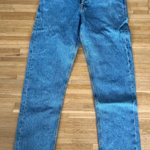 Loose fit jeans blå 29/32 - Blå loose fit jeans i klassisk modell med raka ben och normal midja. Snygg tvätt och klassiska bakfickor med broderad detalj. Perfekta för en avslappnad stil och tillverkade i slitstarkt jeanstyg.