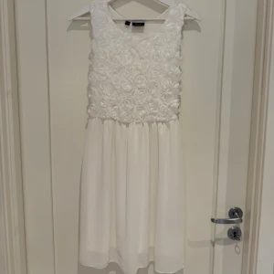 Vit kortklänning med blommor  - URGULLIG vit klänning med blommor🥹✨ aldrig använd då jag köpte den som ”extraklänning” till min student. Perfekt för fest eller student💗passar XS & S