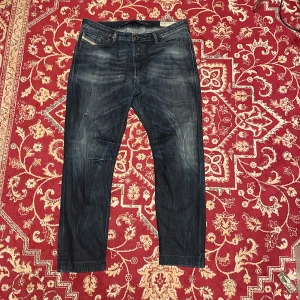 Diesel - Säljer ett par Levi's 511 jeans i mörkblå tvätt med snygga slitningar. Klassisk femficksmodell med raka ben och normal passform. Jeansen har läderpatch bak i midjan och är tillverkade i slitstarkt denimtyg.