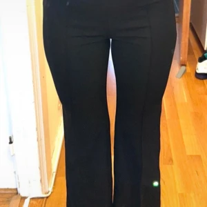 Svarta kostymbyxor med hög midja - Snygga svarta kostym byxor med raka ben. Byxorna har markerad söm framtill. Materialet är tunnt (inte för tunnt, men inte heller som traditionella kostymbyxor) och stretchigt för skön passform.