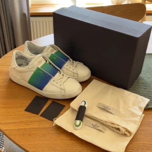 Valentino Garavani sneakers med blå/grön detalj - Snygga vita Valentino Garavani sneakers i skinn storlek 41 passar 42 allt og först till kvarn