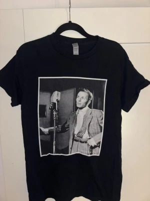 Svart t-shirt med vintage print - Svart t-shirt med coolt vintageinspirerat svartvitt tryck av Frank Sinatra. Klassisk passform och rund halsringning. Perfekt för dig som gillar retro vibes och streetstyle.