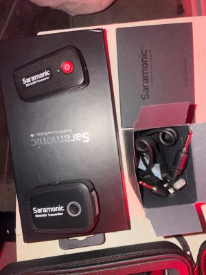 Saramonic Blink500 Wireless Microphone System - Saramonic Blink500 trådlöst mikrofonset med mottagare och sändare, perfekt för video, intervjuer och podcasts. Inkluderar originalkartong, manual och tillbehör som kablar. Produkten ser ut att vara i gott skick utan synliga defekter eller slitage.