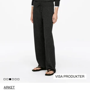 Mörkgrå kashmirbyxor från Arket - Mörkgrå byxor i 100% kashmir från Arket. De har en relaxed passform med breda ben och dragsko i midjan för extra komfort. Perfekta för en chill och stilren look, matcha med sneakers eller sandaler för en avslappnad vibe.