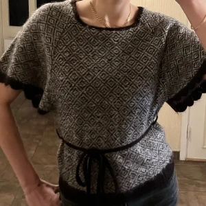  Stickad topp i mohair - Säljer en brun och vit stickad topp från VILA med korta ärmar och ett snyggt mönster. Toppen har bruna kanter, dekorativt knytband i midjan och scallop-detaljer vid ärmslut. Storlek M, men passar perfekt på mig som bär S vanligtvis. 