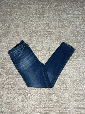 Dondup George   - Hej jag säljer ett par Dondup George i nyaste modellen. Jeansen i riktigt snygg blå färg perfekt för dig som vill ha ett par kvalitetsjeans med grym passform. Nypris ≈4000kr, mitt pris 899kr.  Skick: 9/10 Storlek: W33 Midja: 40cm Lår: 26cm Ytterlängd: 104cm Innerlängd: 80cm  Skriv gärna om du vill ha fler bilder eller har frågor!