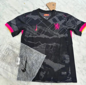 Chelsea FC svart matchtröja - Chelsea FC svart och grå fotbollströja från Nike med korta ärmar, Dri-FIT material och fint mönster. Neonrosa och gula detaljer på ärmslut, rosa lejonemblem på bröstet och Nike-logga. Perfekt för dig som vill sticka ut på planen. Priset kan diskuteras