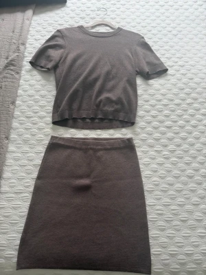 Brun stickad kjol och topp-set - Säljer ett brunt stickat set med kortärmad topp och matchande kjol från gina. Använd 2 ggr säljs på grund av flytt