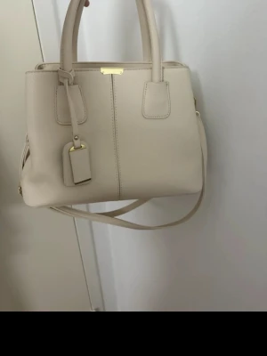 Beige handväska med axelrem - Snygg beige handväska med både handtag och avtagbar axelrem. 💗