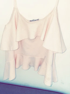 Ljusrosa volangtop från Nelly - Säljer en ljusrosa topp från Nelly i storlek XS. Toppen har tunna axelband och flera lager med volanger som ger en cool och lekfull look. Materialet är strukturerat och känns mjukt mot huden. Perfekt för dig som gillar romantiska detaljer och vill sticka ut.