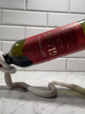 Stilfull design – ge vin och glögg en vacker plats - Hej! Vi erbjuder flera stilfulla vin- och glöggflaskhållare – och just denna eleganta design är resultatet av mycket omsorg och noggrant arbete.  Flaskhållaren är en vacker inredningsdetalj som passar perfekt att ha framme i köket, vardagsrummet eller där du vill skapa en extra dekorativ touch.  Finns i färgerna: vit och svart. ✨ Gör serveringen lyxigare med vår exklusiva flaskhållare.  Varmt välkommen att beställa!