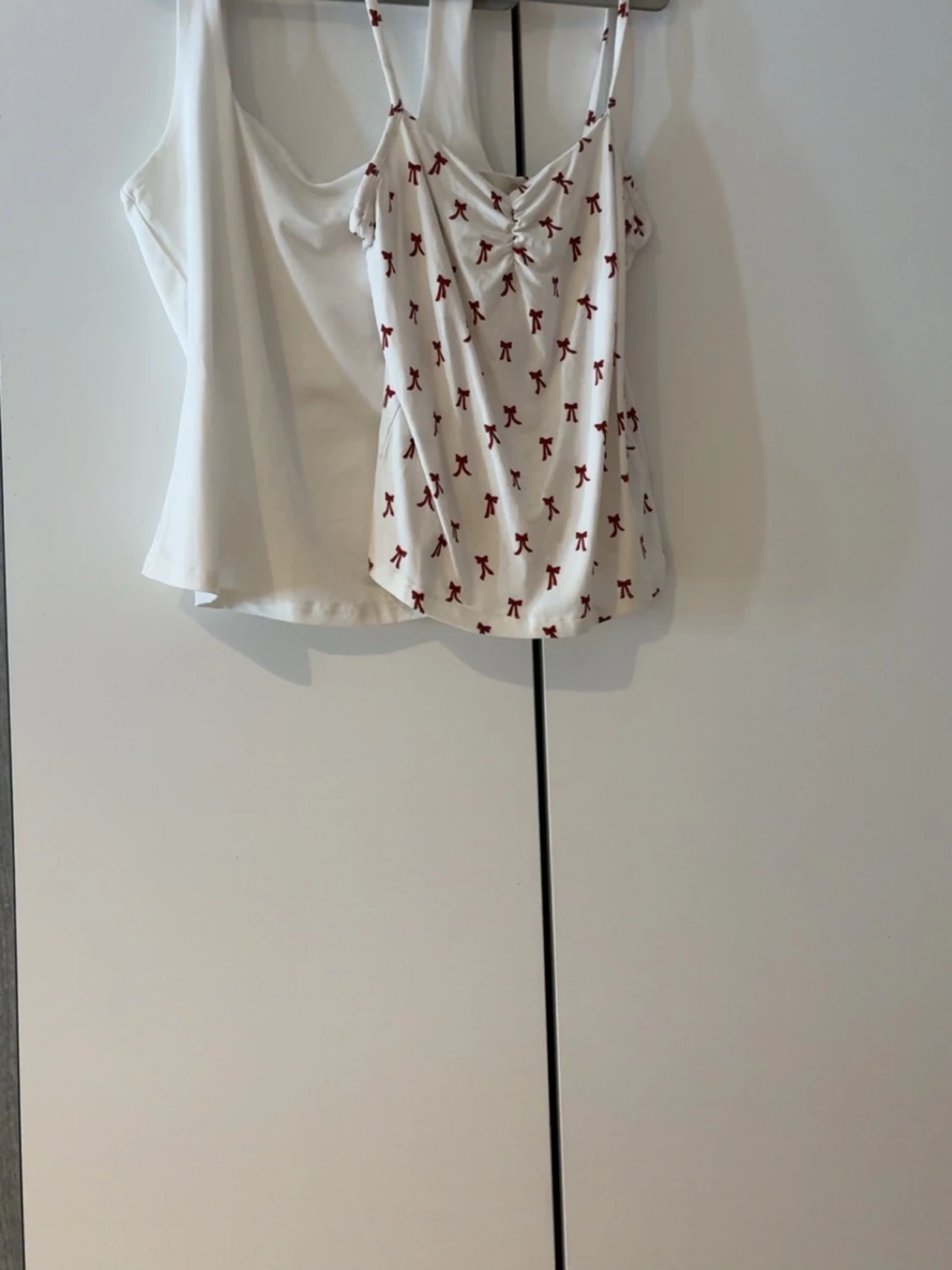 Två vita linnetoppar med rosettprint