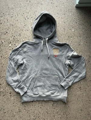 Grå Morris Hoodie  - Grå Morris hoodie i storlek M men är lite mindre i storleken. Det är inget fel med den förutom ett litet hål (vid sista bilden). Jag försöker frakta så snabbt som möjligt. Skriv vid frågor. 