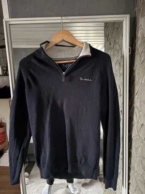 Marinblå half zip tröja Bondelid S - Snygg marinblå tröja från Bondelid med halv dragkedja och ribbade detaljer vid axlar och muddar. Tröjan har en krage med ljusgrå insida och broderad Bondelid-logga på bröstet. Perfekt för dig som gillar klassisk stil med modern touch.