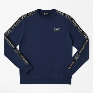 Blå långärmad tröja från EA7 - Snygg marinblå långärmad tröja från EA7 Emporio Armani med logga på bröstet och tryck längs ärmarna. Tröjan har rund halsringning och är gjord i mjuk bomull, perfekt för en stilren och sportig look.