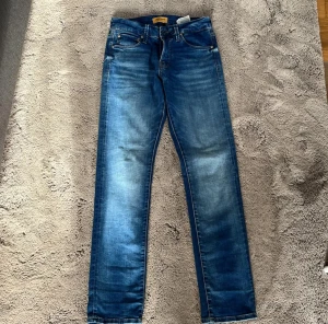 Blå jeans från Jack & Jones - Säljer ett par ljusblåa slim fit jeans (Gleen) storlek 27W, 30L. Säljer dessa fina jeans eftersom jag vuxit ur storleken men annars enkelt o kort sagt är dessa mina favorit jeans.