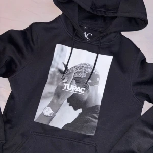 Tupac hoodie - Svart hoodie med tupac tryck. Mycket fint skick. Bara hör av dig vid frågor eller funderingar.