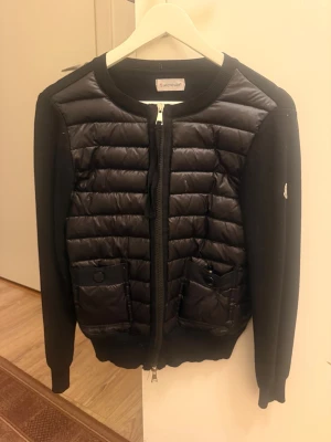 Svart Moncler jacka  - Svart moncler jacka i strl S. Jackan har använts under en vår säsong🫶🏼 Man kan se en liten skada på sida 2 men annars är jackan bra. Pris går att diskutera vid snabb affär💗