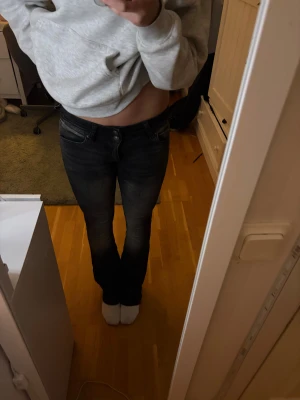 Svarta bootcut jeans från Bershka - Snygga svarta jeans från Bershka med bootcut passform och ljusa slitningar framtill. Så snygga och passar till allt. Tror inte de säljs längre .