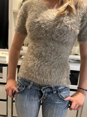 Beige fluffig topp - Säljer en beige fluffig topp med korta ärmar och rund hals. 