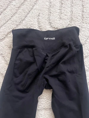 Svarta DFYNE Impact Leggings XS - Säljer ett par svarta DFYNE Impact Leggings i storlek XS. De har hög midja och är tillverkade i ett stretchigt material med 90% nylon och 10% elastan. 