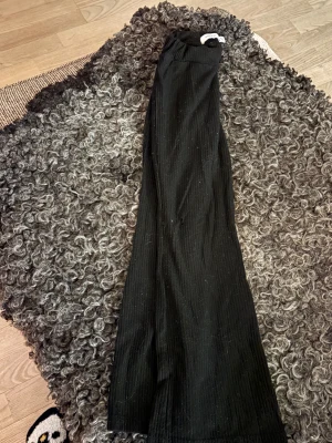 Svarta ribbade wide byxor (jazzbyxor) från NAME IT - Svarta ribbade byxor från NAME It med breda ben och elastisk midja. Byxorna har en skön och loose passform, tillverkade i mjukt material som ger en chill vibe. Perfekta för dig som gillar stilrena och bekväma plagg.