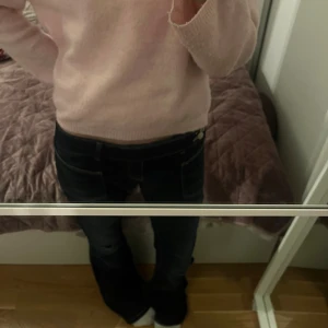 Mörkblå bootcut jeans Gina Tricot - Snygga mörkblå jeans från Gina Tricot med bootcut passform och låg midja. Jeansen har slitna detaljer vid knäna, stora fickor fram och dubbla knappar i midjan. Materialet är klassisk jeans med lite stretch för extra komfort.