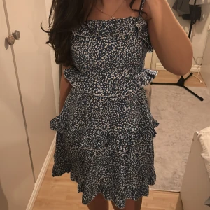 Blåvit volangklänning med mönster - Blå klänning med vita mönster och volanger 